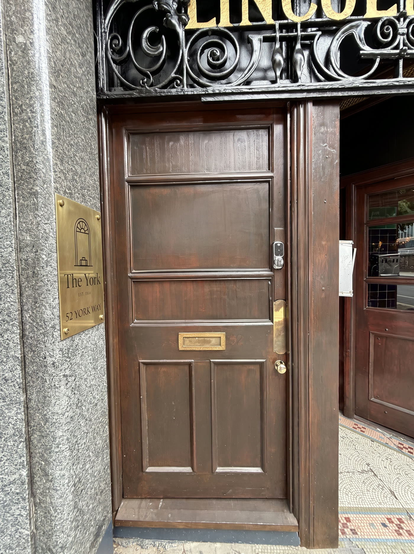 Aged brass plate at eye height on the stone pillar
