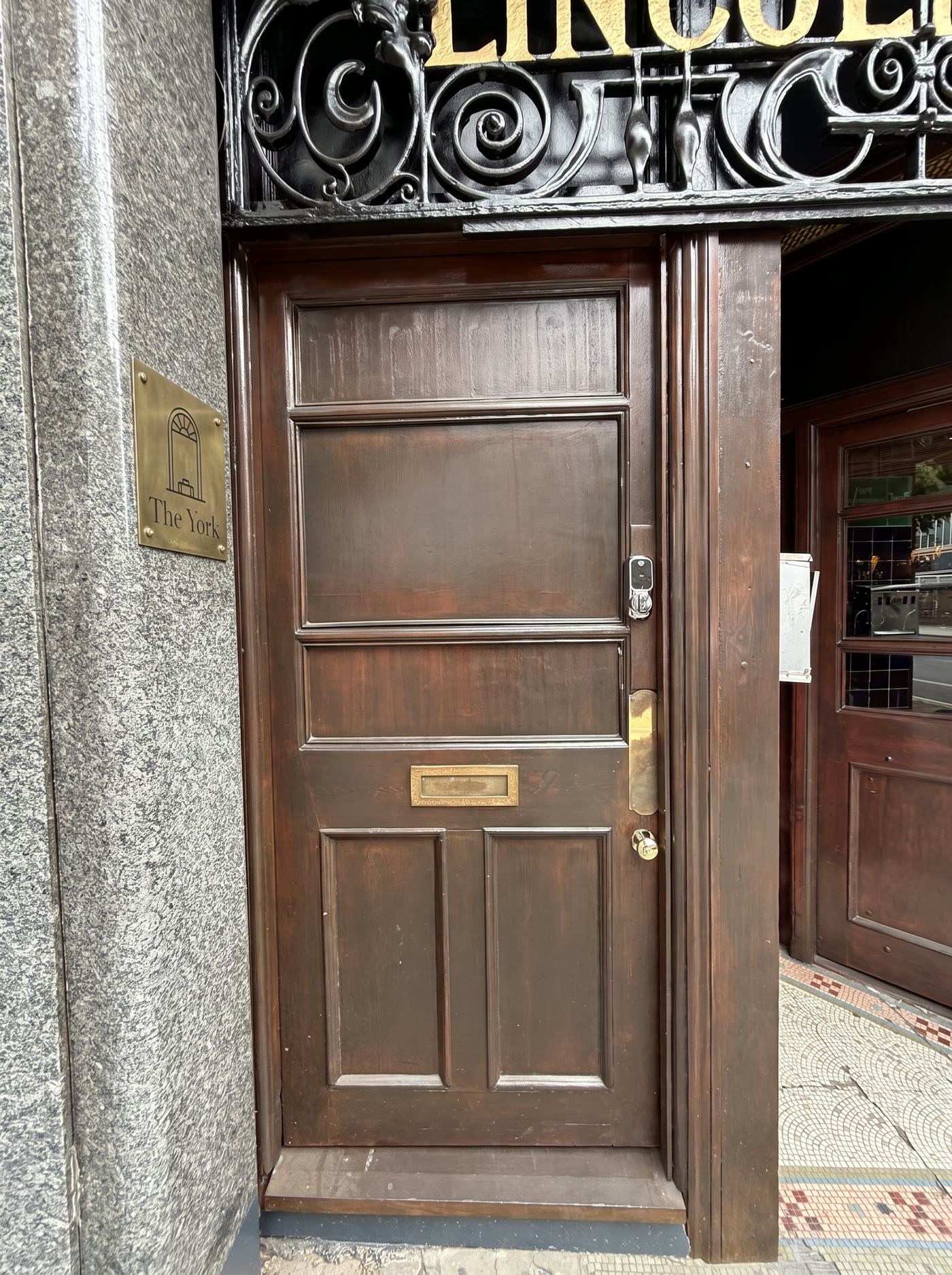 Small brass plate set high on the stone pillar